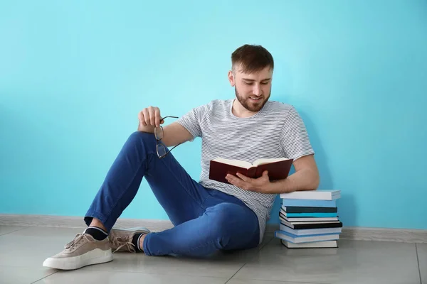 Mladý Muž Čtení Knihy Vsedě Barevné Stěny — Stock fotografie