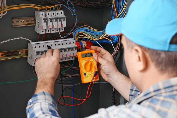 Mature Electrician Measuring Voltage Distribution Board — Stock Photo, Image