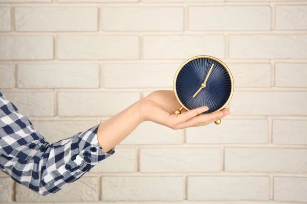レンガの壁の近く時計を保持している女性 時間管理の概念 — ストック写真