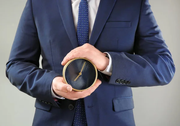 Man Håller Väckarklocka Grå Bakgrund Time Management Koncept — Stockfoto