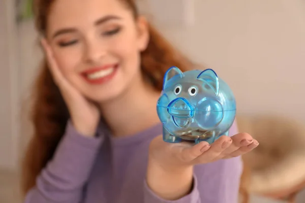 年轻女子抱着小猪银行在室内 货币储蓄概念 — 图库照片