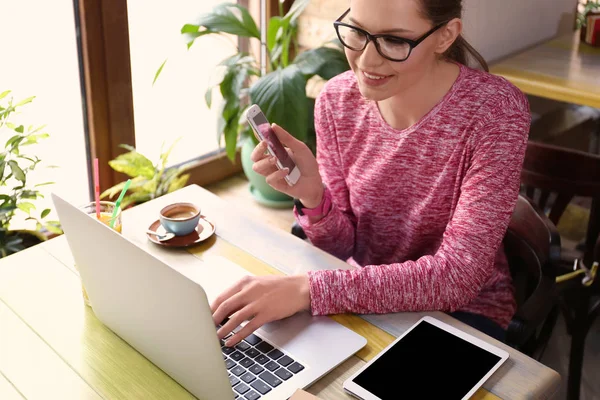 Ung Frilansare Med Mobiltelefon Och Bärbar Dator Arbetar Café — Stockfoto