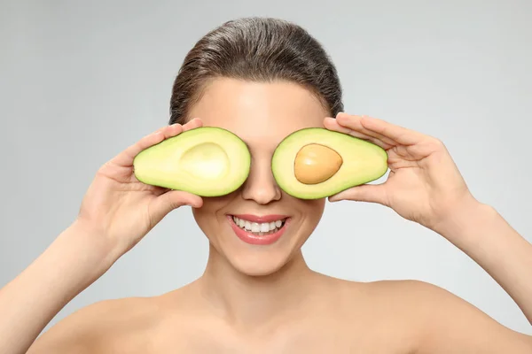 Mujer Joven Divertida Con Aguacate Sobre Fondo Claro —  Fotos de Stock