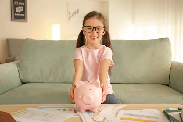 室内でソファーに座っていた貯金と幸せな小さな女の子 お金の節約のコンセプト — ストック写真