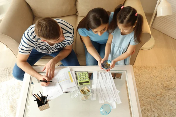 Family with pay bills, calculator and money counting expenses indoors. Money savings concept