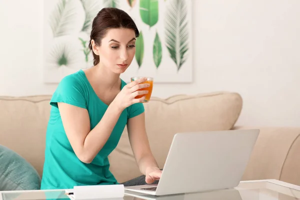 Young Female Freelancer Drinking Juice While Working Laptop Home — Stock Photo, Image