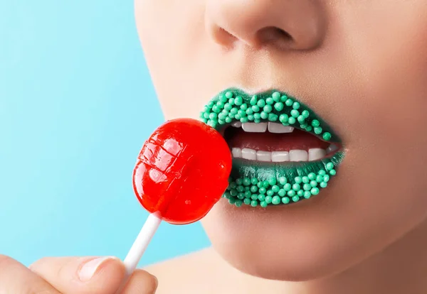 Hermosa Mujer Joven Con Maquillaje Creativo Piruleta Sobre Fondo Color — Foto de Stock