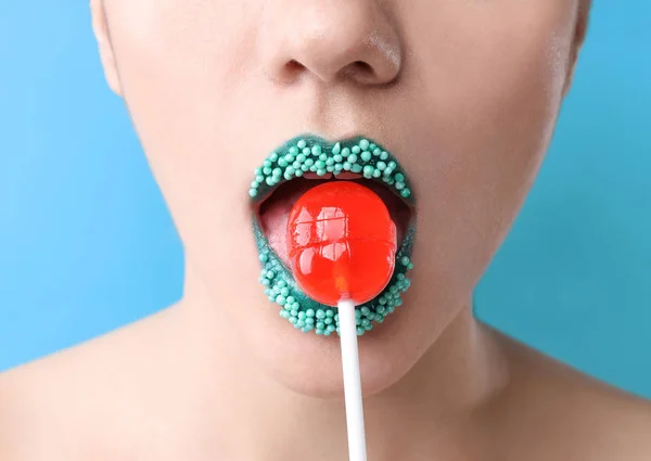 Hermosa Mujer Joven Con Maquillaje Creativo Piruleta Sobre Fondo Color — Foto de Stock