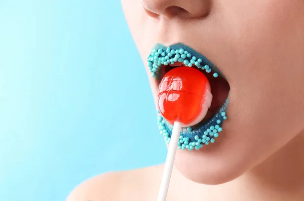 Hermosa Mujer Joven Con Maquillaje Creativo Piruleta Sobre Fondo Color — Foto de Stock