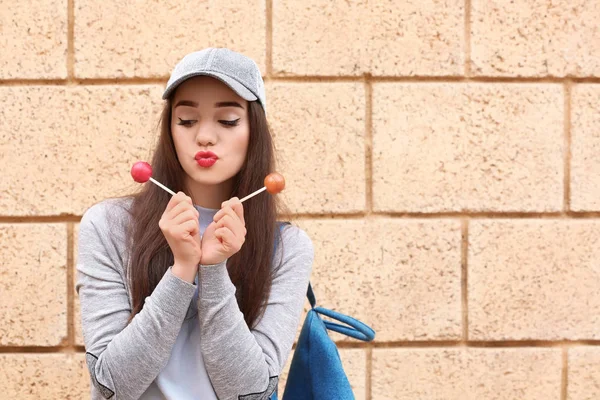 Attractive young woman with lollipops outdoors