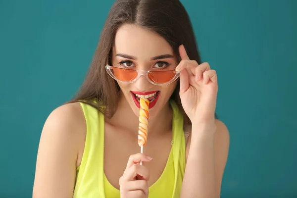 有吸引力的年轻妇女与棒糖在颜色背景 — 图库照片