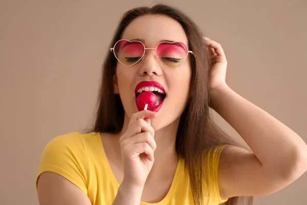 有吸引力的年轻妇女与棒糖在颜色背景 — 图库照片