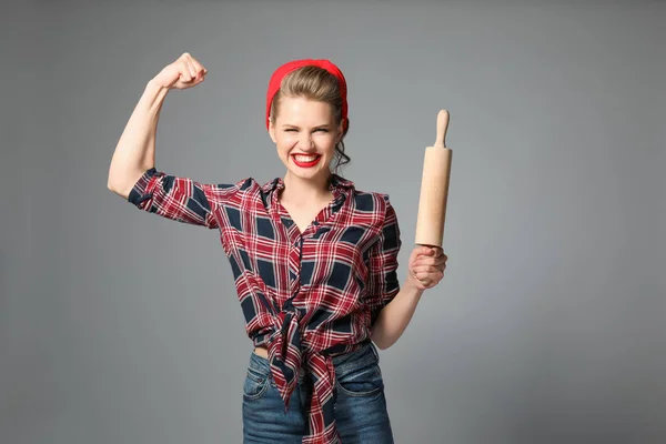 灰色の背景に麺棒を持つ強力な若い女性 — ストック写真