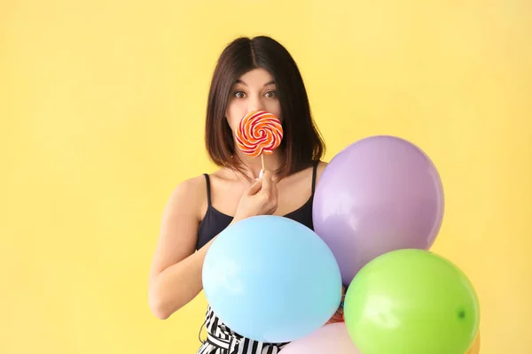 Schöne Junge Frau Mit Lutscher Und Luftballons Auf Farbigem Hintergrund — Stockfoto