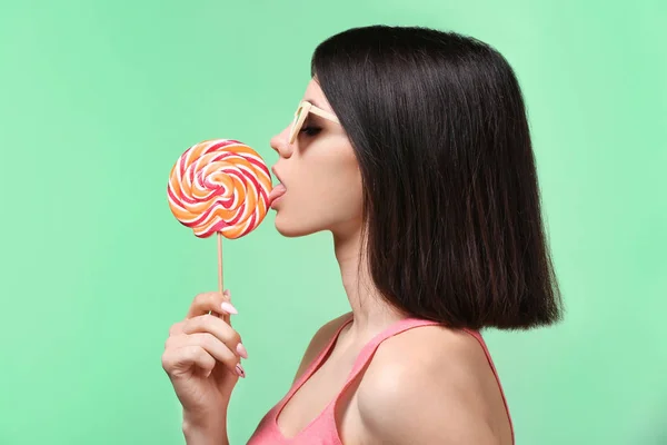色の背景上のロリポップと美しい若い女性 — ストック写真