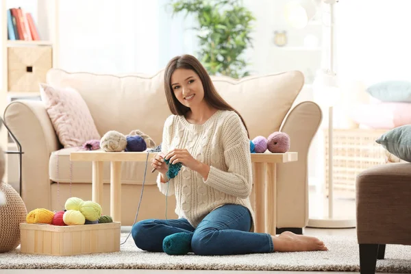 屋内で暖かいセーターを編む若い女性 — ストック写真
