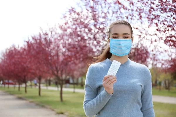 Young Woman Protective Mask Holding Pills Blooming Trees Allergy Concept — Stock Photo, Image