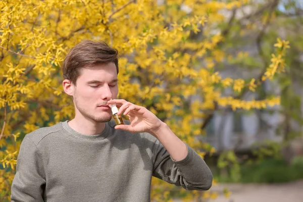 Hombre Joven Usando Gotas Nasales Cerca Del Árbol Floreciente Concepto —  Fotos de Stock