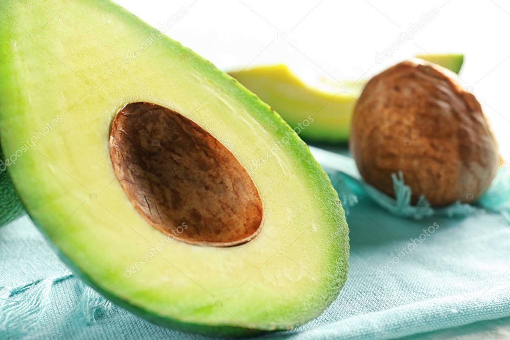 Fresh cut avocado and pit on table, closeup