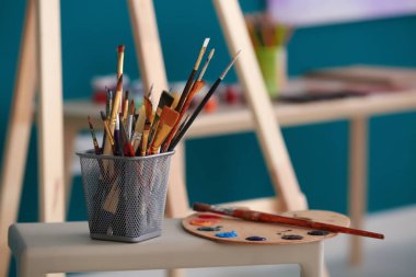 Araçları ve profesyonel sanatçının atölyesinde masada boyalar