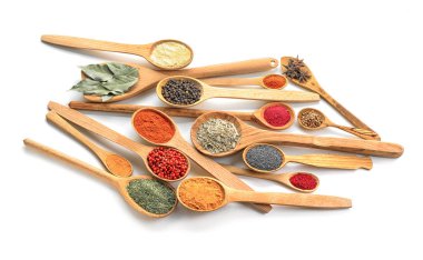 Beyaz arka plan üzerinde çeşitli baharatlar ile tahta kaşıklar