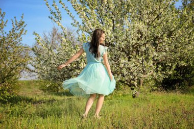 Güneşli bahar gününde çiçek açması tree yakınındaki güzel genç kadın