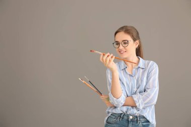 Gri arka plan üzerinde kadın sanatçı portresi