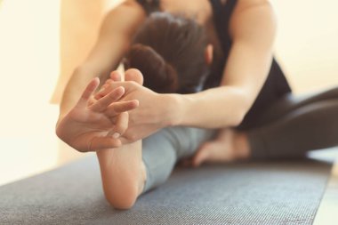 Evde yoga yapan genç bir kadın.