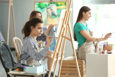 Ressamlar okulda sınıflar sırasında kız öğrenci