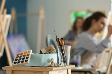 Boyalar ve sanatçının atölyesinde araçları içeren tablo