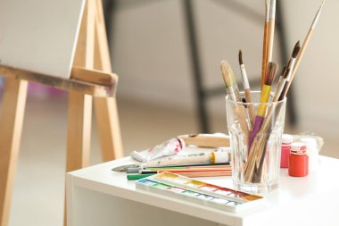 Boyalar ve sanatçının atölyesinde araçları içeren tablo