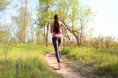 Parkta çalıştıran sportif genç kadın