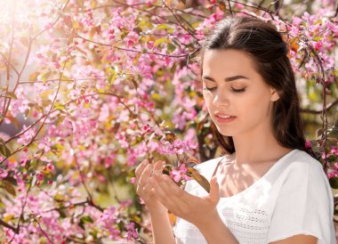 Güzel genç kadının yanına park bahar gününde çiçek açan ağaç