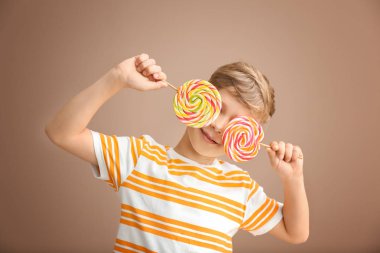 Lolipop renk arka plan üzerinde olan şirin küçük çocuk