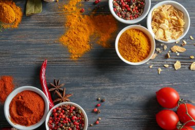 Ahşap arka plan üzerinde çeşitli baharatlar ile kase