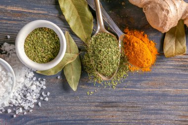 Kase ve kaşık ahşap arka plan üzerinde çeşitli baharatlar ile