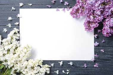 Boş kartı ve ahşap zemin üzerine çiçek açması leylak kompozisyonu