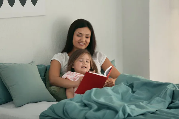 母と娘が一緒に家で本を読んで — ストック写真