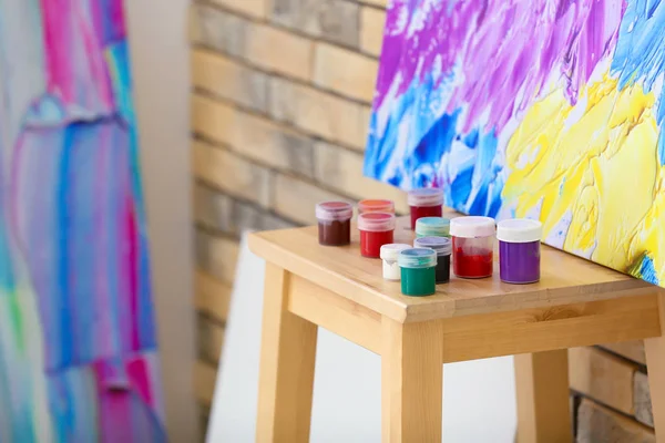 Paints on chair in artist\'s workshop