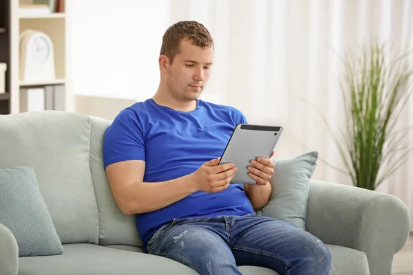Junger Mann Benutzt Tablet Während Hause Auf Dem Sofa Liegt — Stockfoto