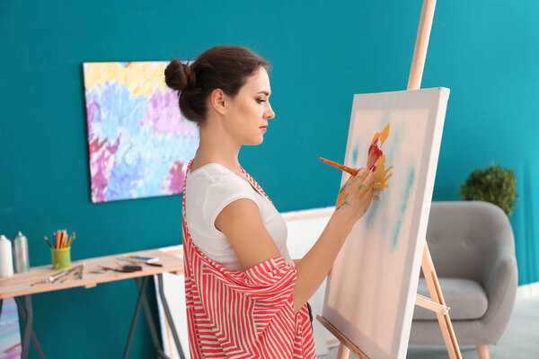 Female artist painting picture in workshop