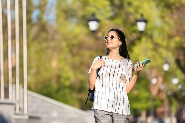 音楽を聞きながら公園を歩いて美しい若い女性 — ストック写真