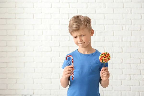 Lindo Niño Con Piruleta Bastón Caramelo Cerca Pared Ladrillo Blanco — Foto de Stock