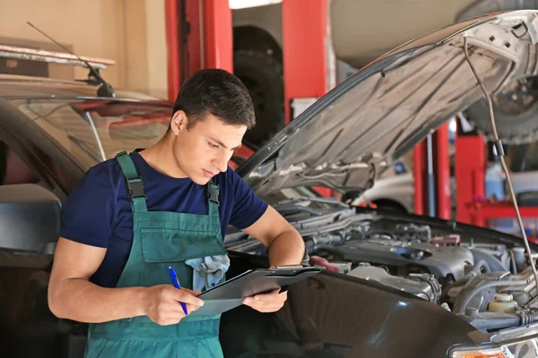 Joven Mecánico Automóviles Con Portapapeles Cerca Coche Centro Servicio — Foto de Stock