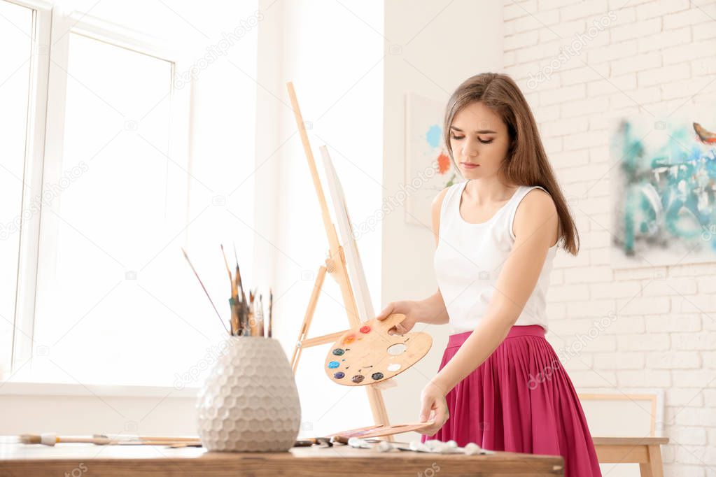 Young female artist working in studio