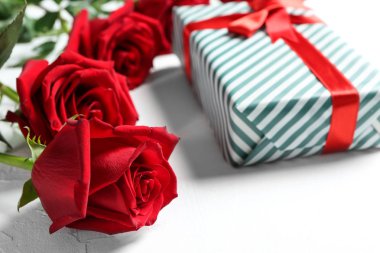 Hediye kutusu ve beyaz arka plan üzerinde güzel güller