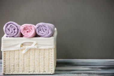 Hasır sepet havlu üzerinde gri bir arka plana dayanır ahşap masa ile