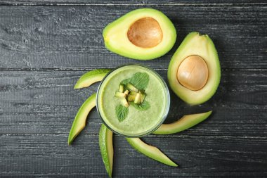 Olgun avokado ve cam ahşap arka plan üzerinde lezzetli güler yüzlü