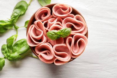 Lezzetli bir kase dilimlenmiş ve ham ahşap masa, üstten görünüm haddelenmiş