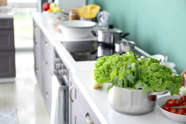 Marul ve modern mutfak masasında kuzukulağı ile tencere
